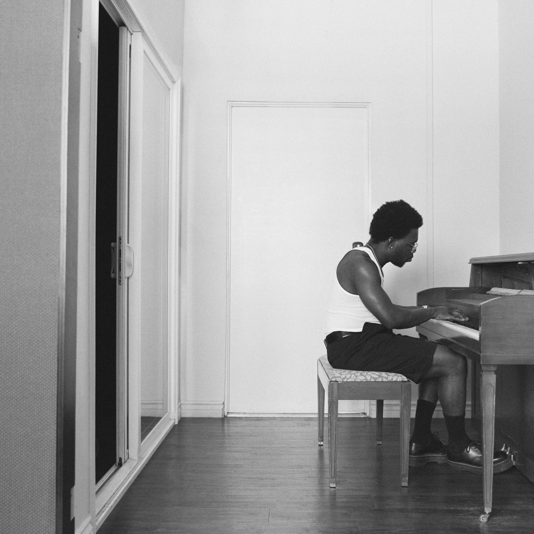Jay James playing an upright piano